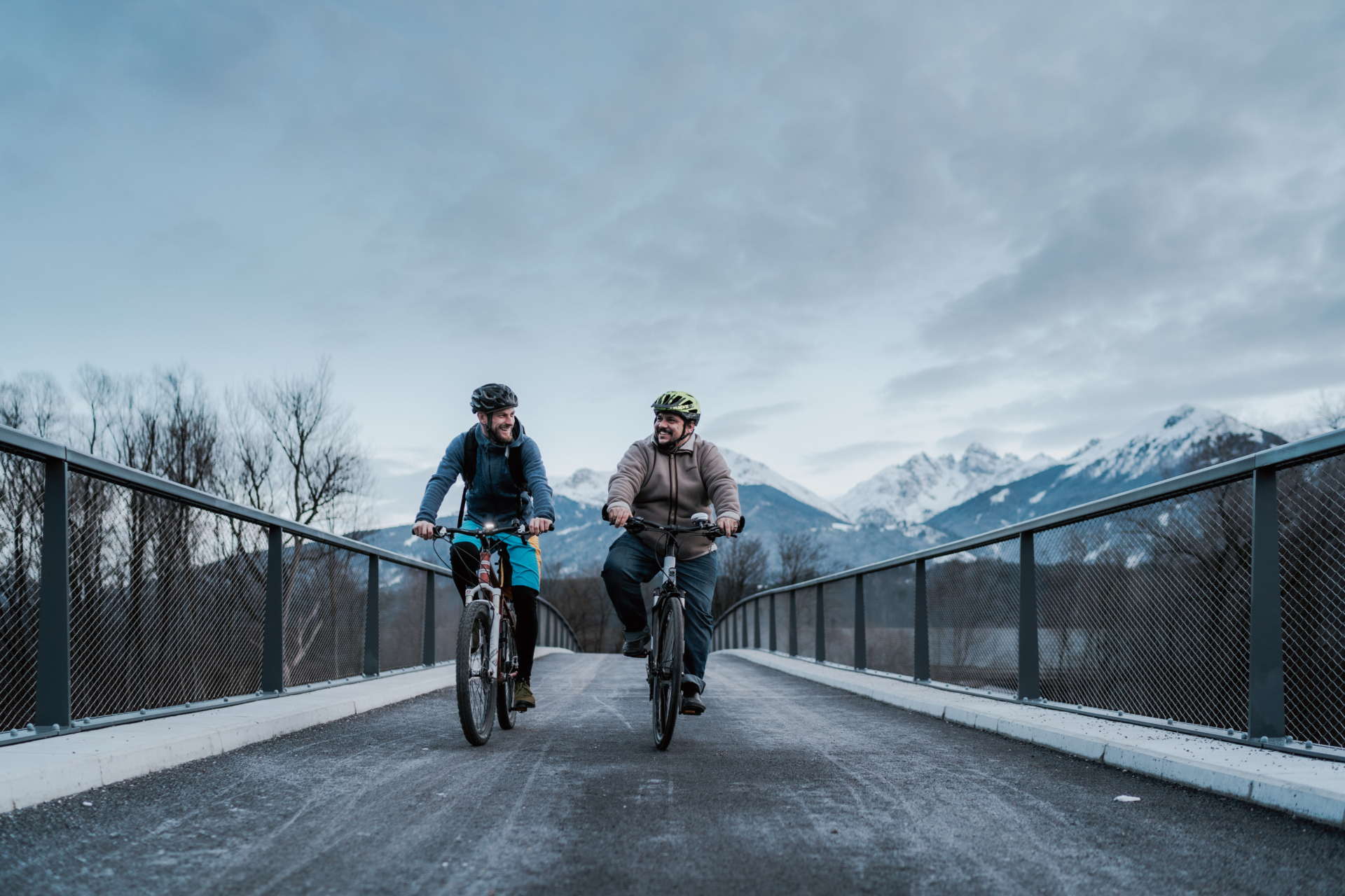 Zwei Männer fahren über Fahrrad Brücke mit Rad:
