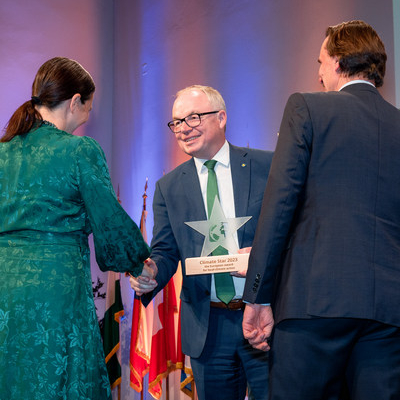 Landesrat Stephan Pernkopf übergibt den Climate Star Pokal an zwei Personen.