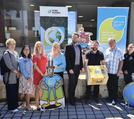 Gruppenfoto mit zwei Rollups im Hintegrund, eine Person hat die Holzkiste der Klimakiste in der Hand