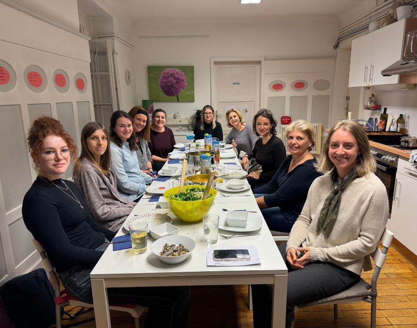 Gruppenbild, Menschen sitzen an gedecktem Tisch mit vielen guten Speise