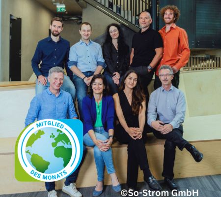 Gruppenbild von neun Personen, vier sitzen, vier stehen mittleren alters business casual und Klimabündnis Mitglied des Monats Logos links unten