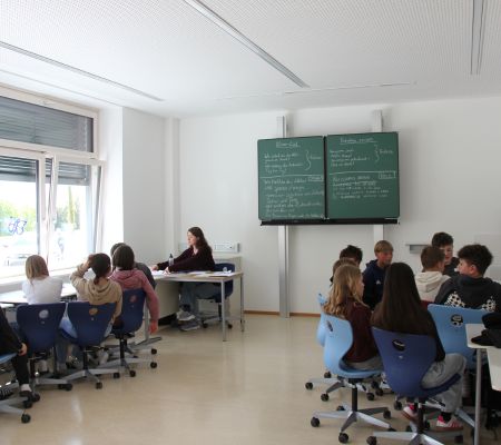 Schülerinnen und Schüler sitzen in der Klasse und hören dem Unterricht zu