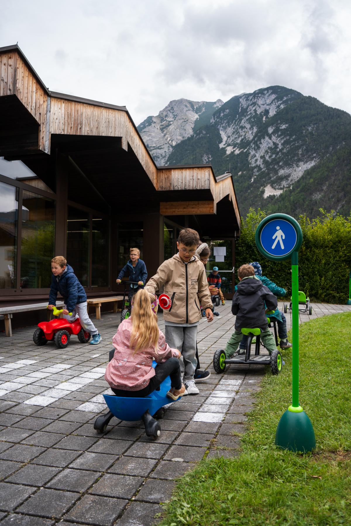 Kinder fahren mit verschiedenen Fahrzeugen auf Schulhof
